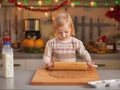 Baby rolling pin dough in christmas decorated kitchen Royalty Free Stock Photo