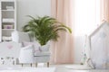 Baby room with armchair, crib and plant Royalty Free Stock Photo