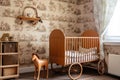 baby room, with crib and rocking horse against the backdrop of old-fashioned wallpaper