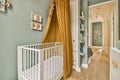 a baby room with a crib and a yellow curtain