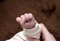 Baby`s baby hand close-up. The child sleeps and put his hand on the brown plaid