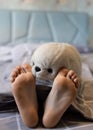 baby's bare feet on the bed close-up and a soft fluffy toy seal face. Good morning Royalty Free Stock Photo