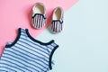 Baby`s clothes on coloured background. Undershirt and tiny shoes for infant or toddler. Flat lay design.