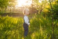 Baby`s first independent steps in the garden in sunlight. Cute summer blond girl laughing in the garden. Royalty Free Stock Photo