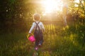 Baby`s first independent steps in the garden in sunlight. Cute summer blond girl laughing in the garden. Royalty Free Stock Photo