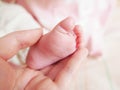 Baby's foot and the hand of parent