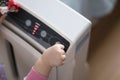 The baby`s hand pressing the power button on the air purifier to clean up the polluted air