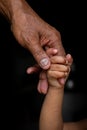 A baby`s hands holding tightly A senior man`s old age finger. Royalty Free Stock Photo