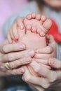 Baby`s legs and mom`s hands are interlaced