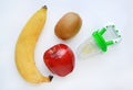 Baby`s nibbler and fresh ripe fruits apple, banana and kiwi on white background Royalty Free Stock Photo