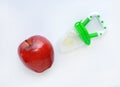 Baby`s nibbler and red apple on white background. Organic baby food concept Royalty Free Stock Photo