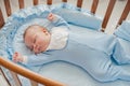 Baby`s restful sleep. Newborn baby in a wooden crib. The baby sleeps in the bedside cradle. Royalty Free Stock Photo