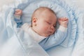 Baby`s restful sleep. Newborn baby in a wooden crib. The baby sleeps in the bedside cradle. Royalty Free Stock Photo