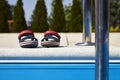 Baby sandals at the edge of swimming pool