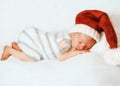 Baby in santa claus hat sleeping in the bed Royalty Free Stock Photo