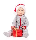 Baby in Santa hat playing with Christmas gift box Royalty Free Stock Photo