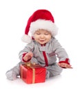 Baby in Santa hat playing with Christmas gift box Royalty Free Stock Photo