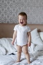 Baby screaming and crying in bed. Tantrums and whims of children.