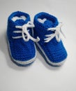 Blue and white handmade knitted child boy booties light background. Royalty Free Stock Photo