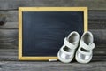 Baby shoes and blank blackboard Royalty Free Stock Photo