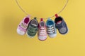 Baby shoes hanging on the clothesline on yellow Royalty Free Stock Photo