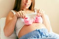 Baby shoes pregnancy woman. Beautiful pregnant woman holding pink baby shoes. Concept of pregnancy, maternity Royalty Free Stock Photo