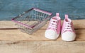 Baby shoes and shopping basket Royalty Free Stock Photo