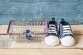 Baby shoes and shopping basket Royalty Free Stock Photo
