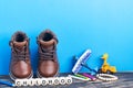 Baby shoes and toys on wooden floor near blue wall. Childhood concept. Copy space for text. The inscription CHILDHOOD from cubes Royalty Free Stock Photo