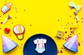 Baby shower. Cookies in shape of accesssories for child, party hats and confetti on yellow background top view copy