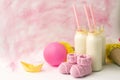 Baby shower decorative table with copy space, pink baby girl booties and bottles with milk in pastel background, idea of baby show