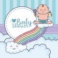 Baby shower little boy with rattle playing rainbow clouds