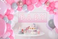 Baby shower party for girl. Tasty treats on table in room with balloons Royalty Free Stock Photo