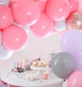 Baby shower party for girl. Treats on table in room decorated with balloons Royalty Free Stock Photo