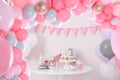 Baby shower party for girl. Treats on table in room decorated with balloons Royalty Free Stock Photo