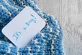 Baby shower `It`s a boy`, announcement card on cozy woolen blue blanket and space for text. New arrival in the family Royalty Free Stock Photo