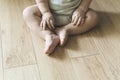 Baby sits on a wooden laminate floor. Bare legs and feet of a baby in the living room floor Royalty Free Stock Photo