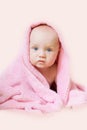 Baby sits, wrapped in a pink towel Royalty Free Stock Photo