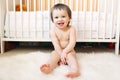 Baby sitting against white bed at home Royalty Free Stock Photo