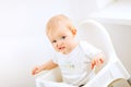 Baby sitting in baby chair and making funny face Royalty Free Stock Photo