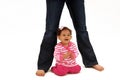 Baby sitting beneath mommy's legs Royalty Free Stock Photo