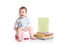 Baby sitting on chamberpot with books Royalty Free Stock Photo