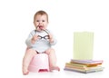 Baby sitting on chamberpot with books Royalty Free Stock Photo