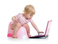 Baby sitting on chamberpot with notebook Royalty Free Stock Photo