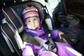 Baby sitting in a child safety seat in forward-facing position on the back car chair, adjustable headrest Royalty Free Stock Photo