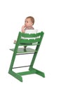 Baby sitting in a highchair on white background Royalty Free Stock Photo