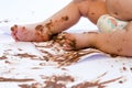 Baby painting with hands with chocolate