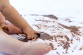 Baby painting with hands with chocolate