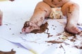 Baby painting with hands with chocolate