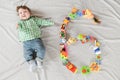 Baby six months top view. Happy baby in a hat and a diaper lying on the background of the carpet, smiling baby Toddler in a shirt Royalty Free Stock Photo